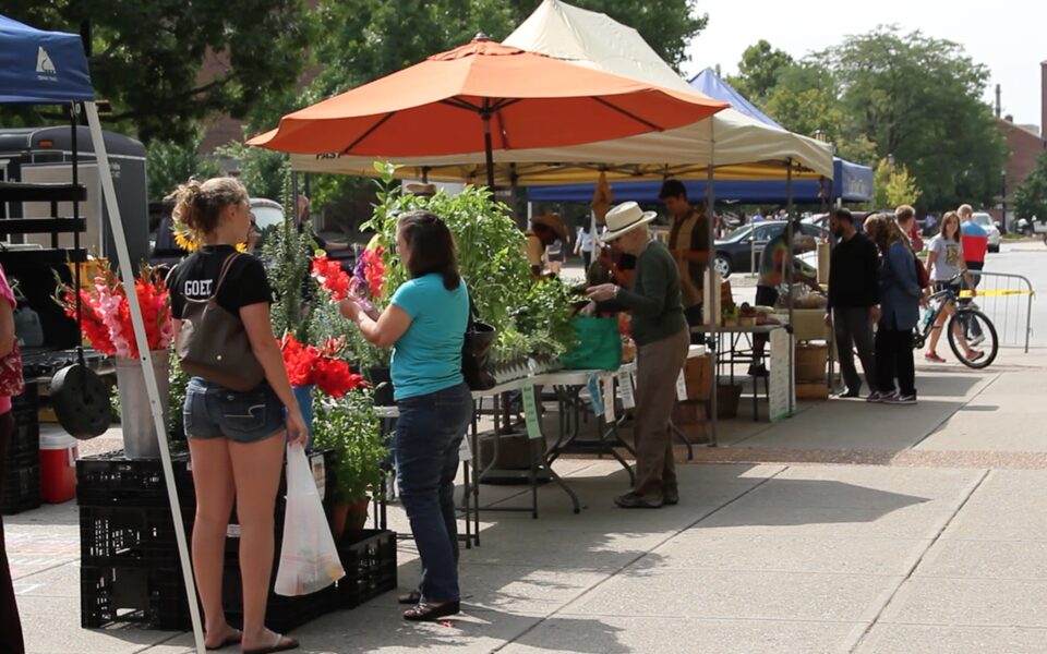 Vendors and visitors at the Purdue Farmers Market on Memorial Mall